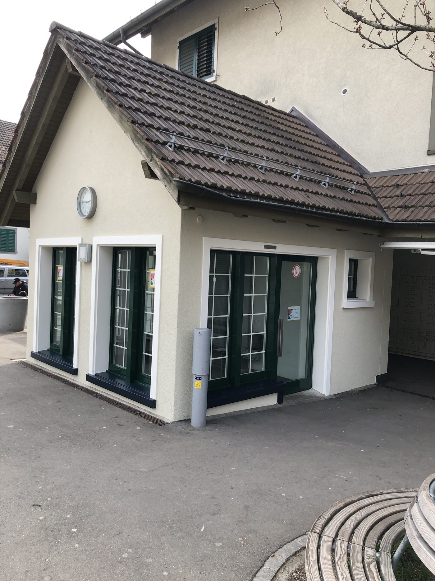 Weiss verputztes Nebengebäude mit dunkelgrünen Fenster- und Türrahmen